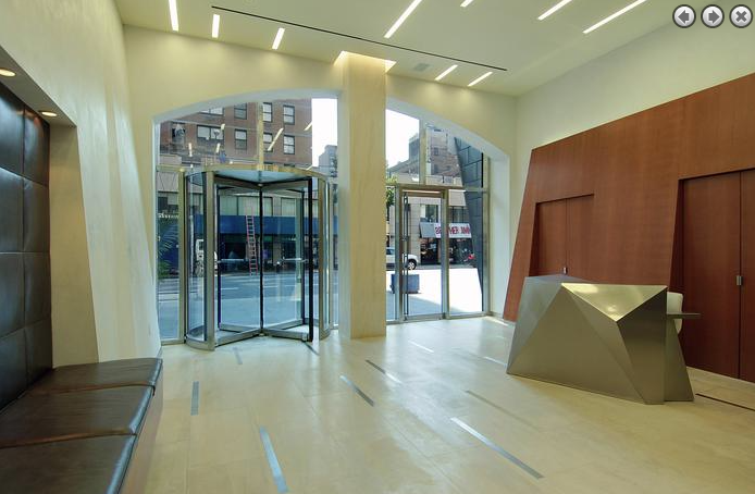 a lobby with a reception desk and a glass door